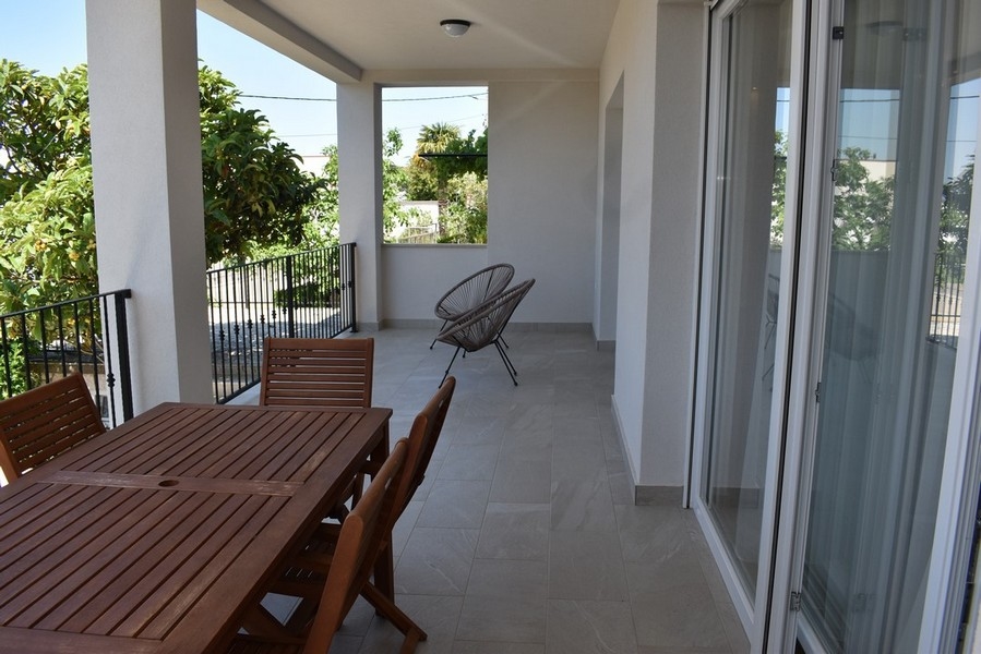 Terrasse couverte avec table à manger et fauteuil rond