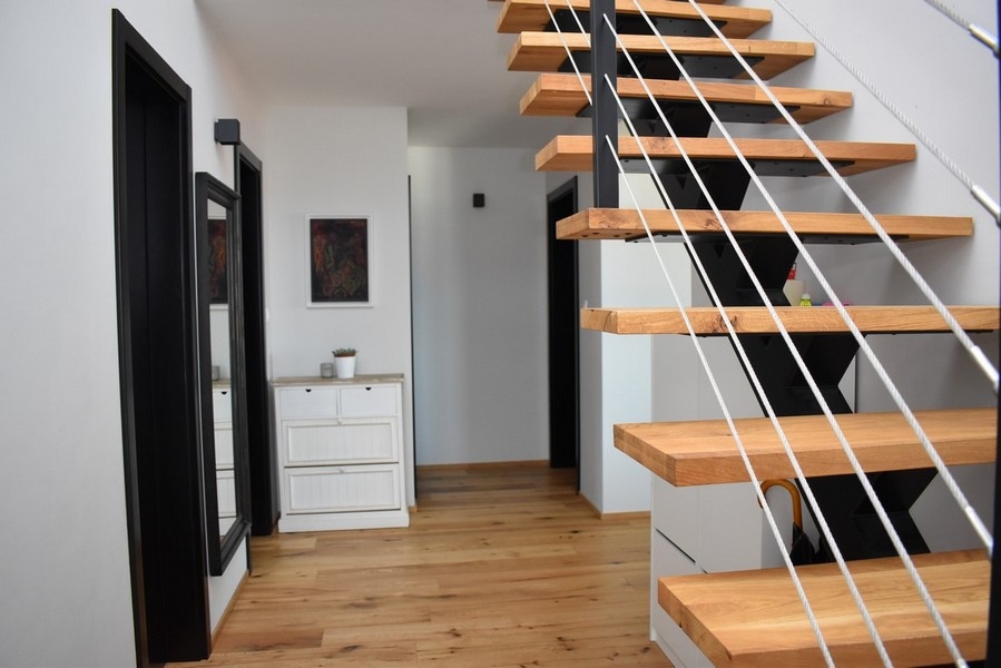 Escalier ouvert en bois avec garde-corps à câbles dans le couloir