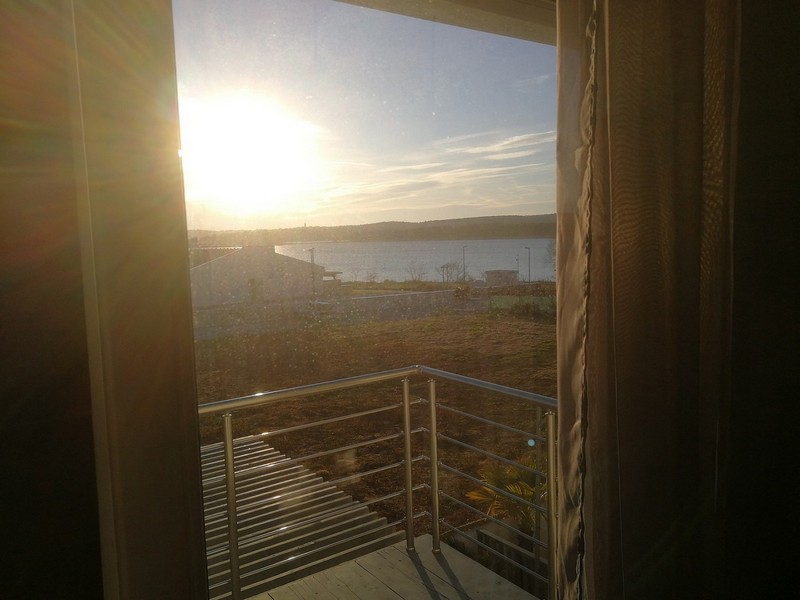 Vue par la porte du balcon sur la baie à contre-jour