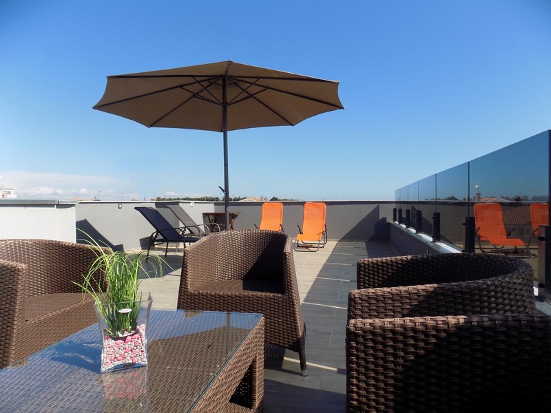 Toit-terrasse avec parasol et meubles en osier