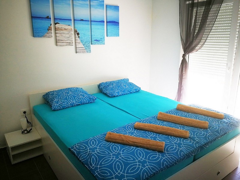 Lit double turquoise sous le tableau de plage