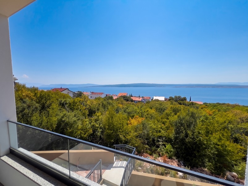 Balcon avec garde-corps en verre et vue sur le maquis jusqu'à la mer