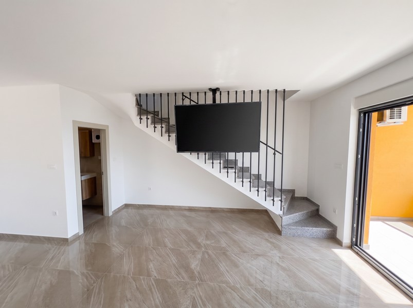 Pièce de vie avec escalier vers l'étage et accès à la salle de bains - H2197