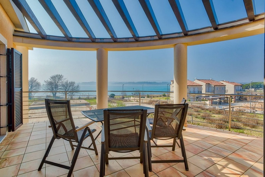 Loggia ronde avec toit en verre et vue sur la baie