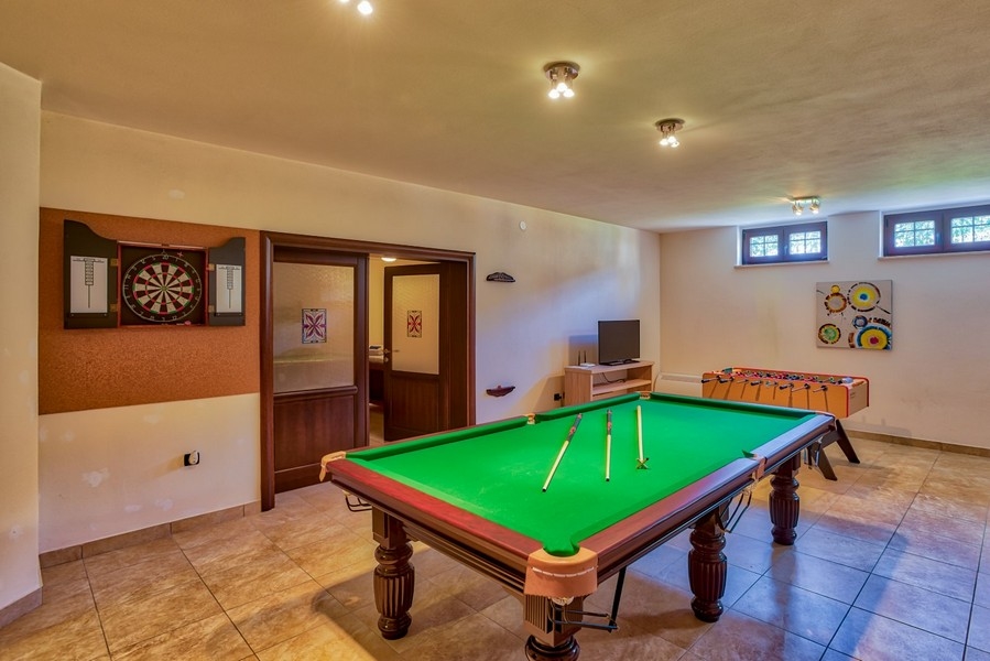 Salle de jeux avec billard, cible de fléchettes et baby-foot