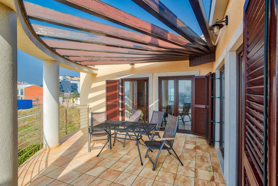 Terrasse sous la pergola en bois avec table et chaises