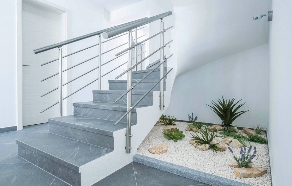 Escalier avec garde-corps en inox à côté du massif de gravier