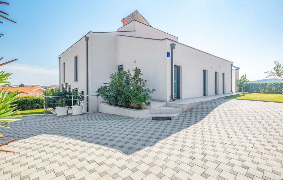 Maison blanche avec lauriers-roses sur la cour pavée