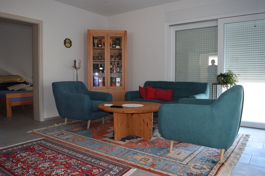 Séjour avec fauteuils bleu pétrole et table en bois