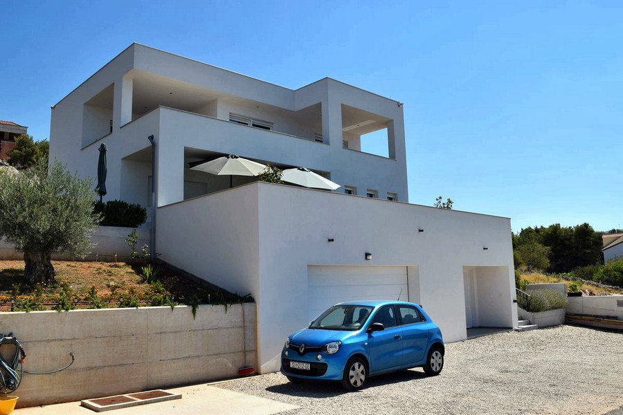 Villa avec parasols sur la terrasse au-dessus du garage