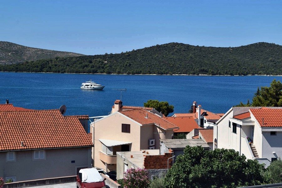 Vue par-dessus les toits de tuiles sur la baie avec bateau d'excursion