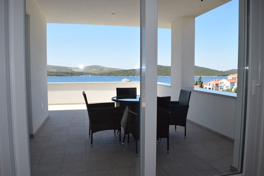 Vue par la porte coulissante sur la loggia avec table à manger