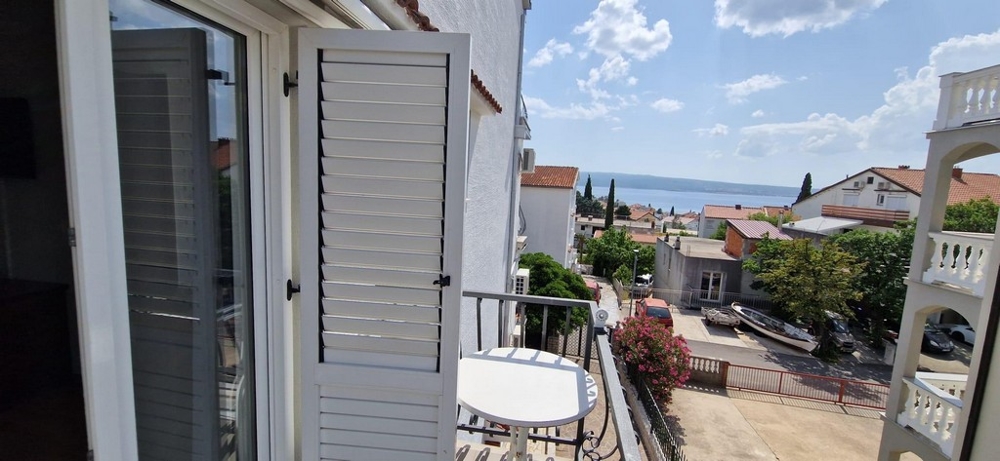 Balcon avec volets battants blancs et vue sur la mer