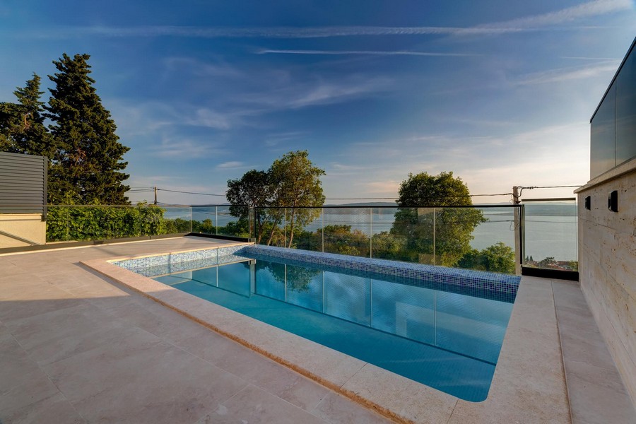 Piscine avec garde-corps en verre et vaste vue sur la baie