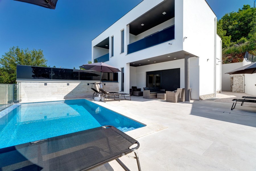 Piscine et lounge devant la maison jumelée avec loggia