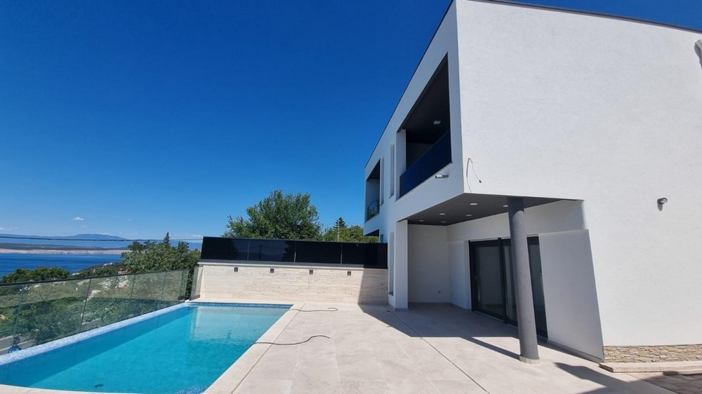 Façade blanche de la maison avec piscine et terrasse à flanc de colline