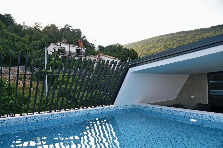 Espace piscine privé avec architecture moderne et brise-vue