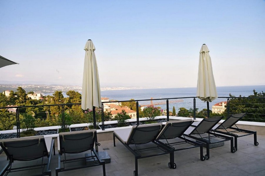 Grand toit-terrasse avec bains de soleil et vue panoramique sur la mer