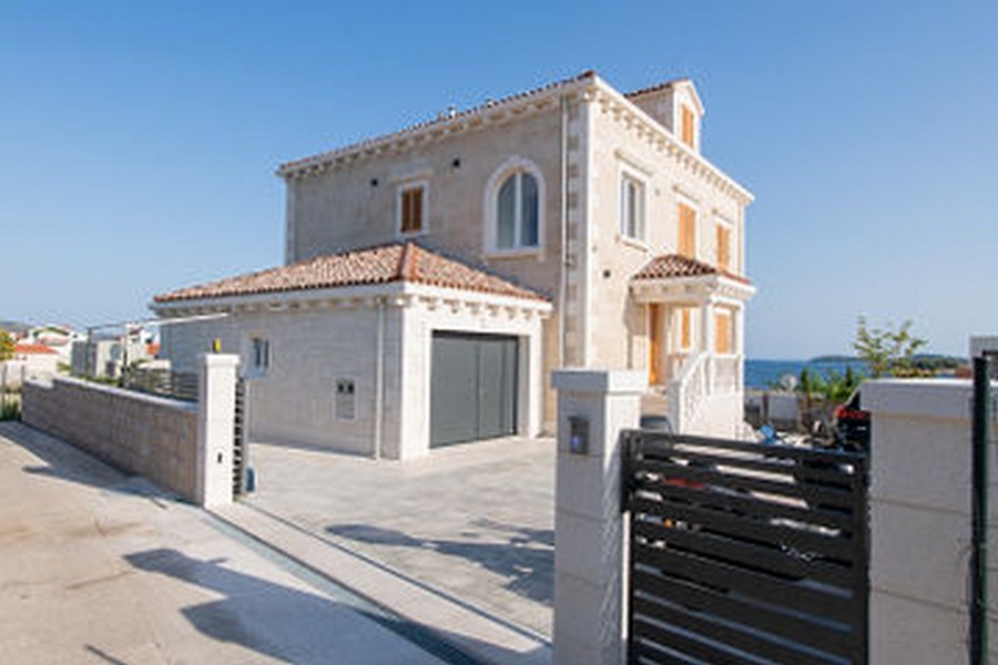Façade de la maison avec garage derrière la clôture à l'accès