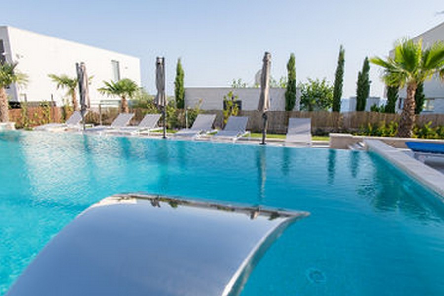 Piscine avec toboggan et bains de soleil sur le bord