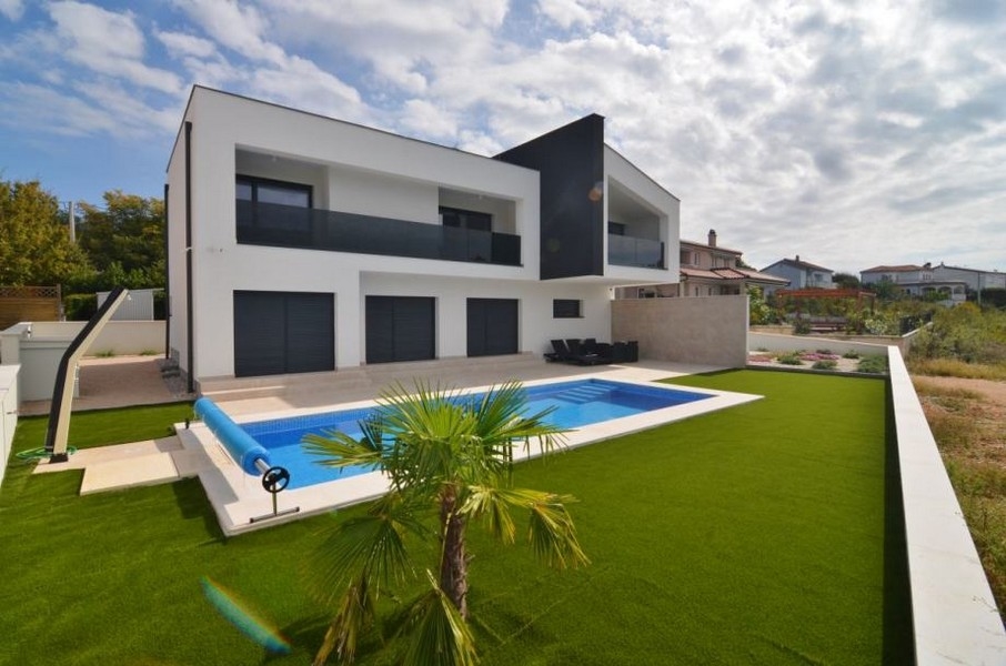 Arrière de la villa avec piscine et jeune palmier dans la pelouse