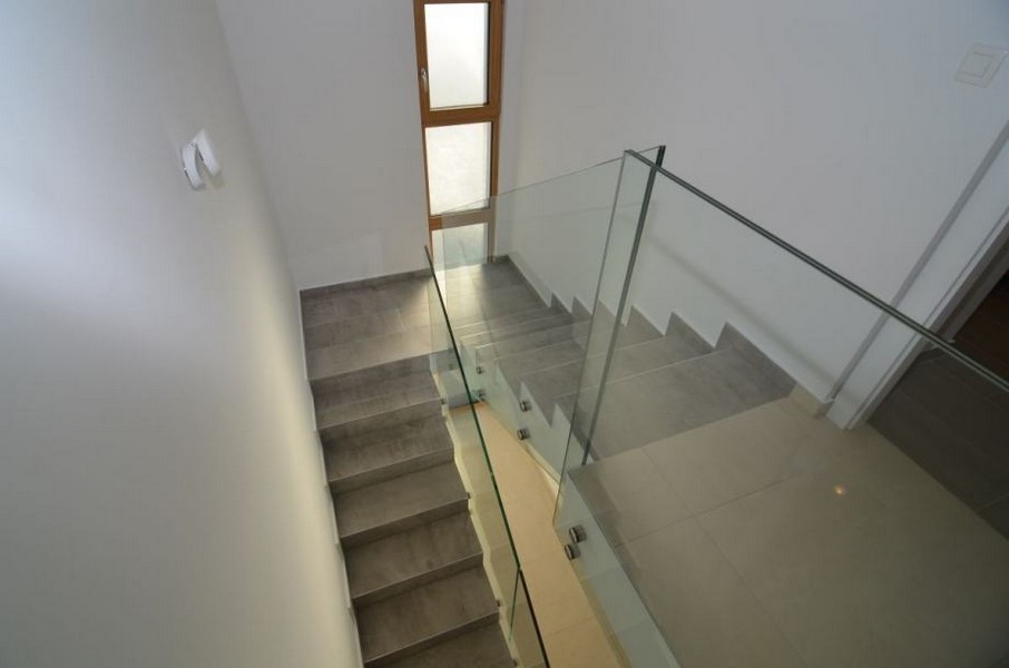 Escalier avec garde-corps en verre descendant vers l'entrée