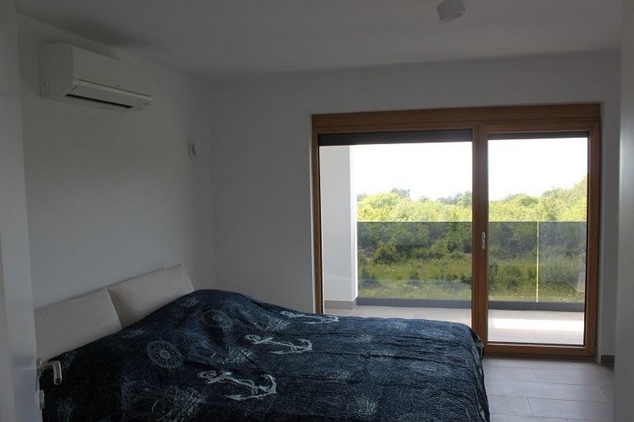 Chambre avec porte coulissante donnant sur le balcon et la verdure