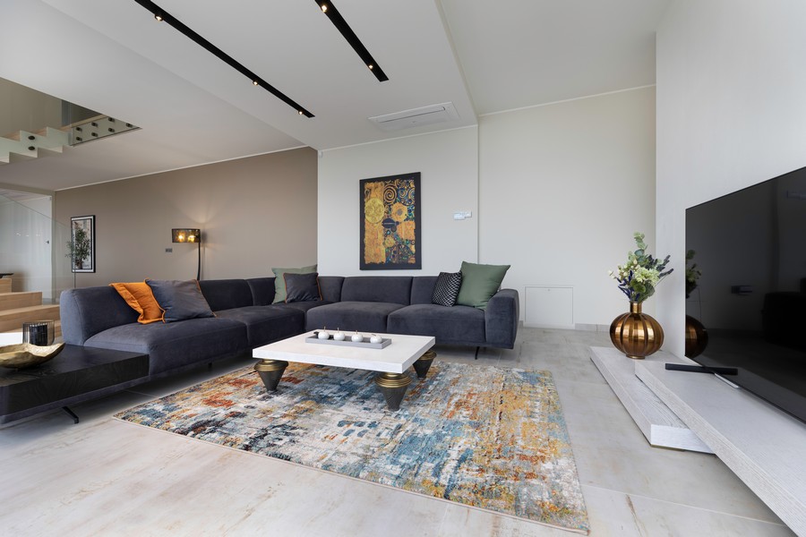 Séjour avec grand canapé d'angle et tapis coloré