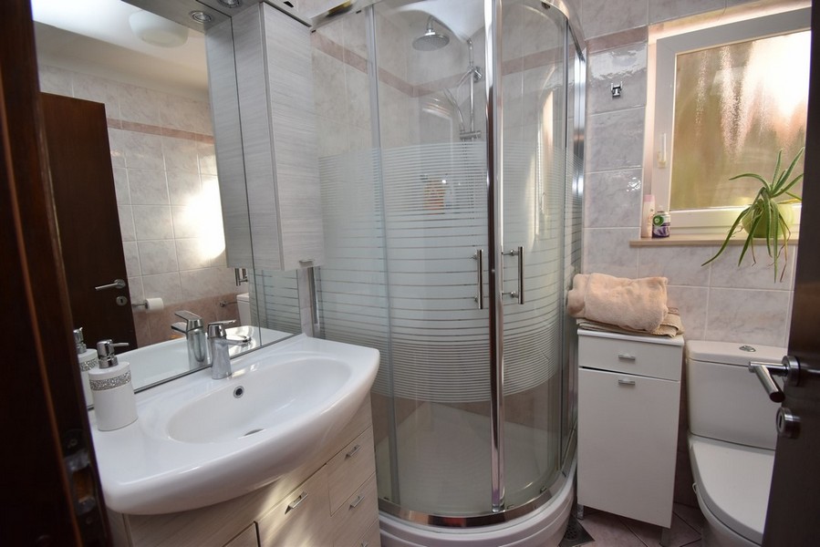 Salle de bains avec cabine de douche ronde et meuble-lavabo