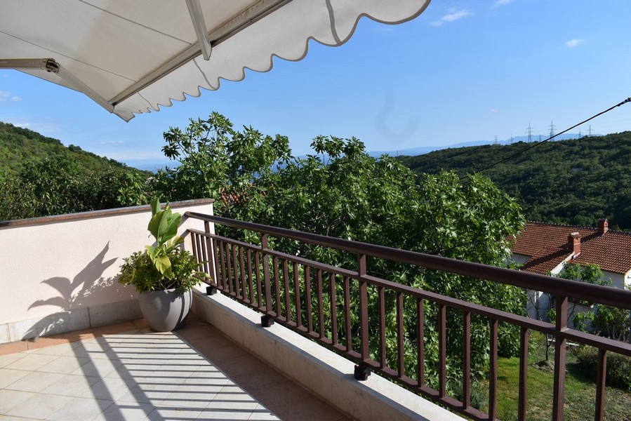 Balcon sous le store avec vue sur les collines