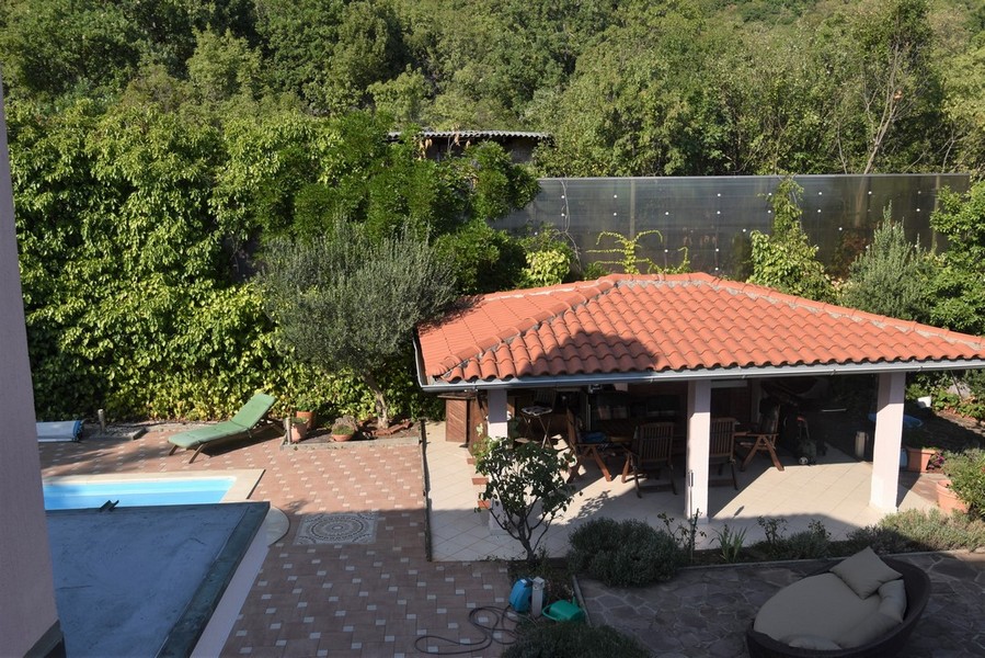 Vue du dessus sur la piscine et la cuisine d'été couverte