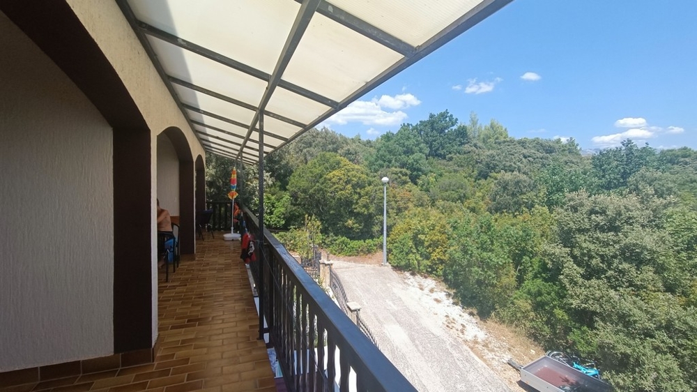 Longue terrasse couverte avec vue sur la verdure