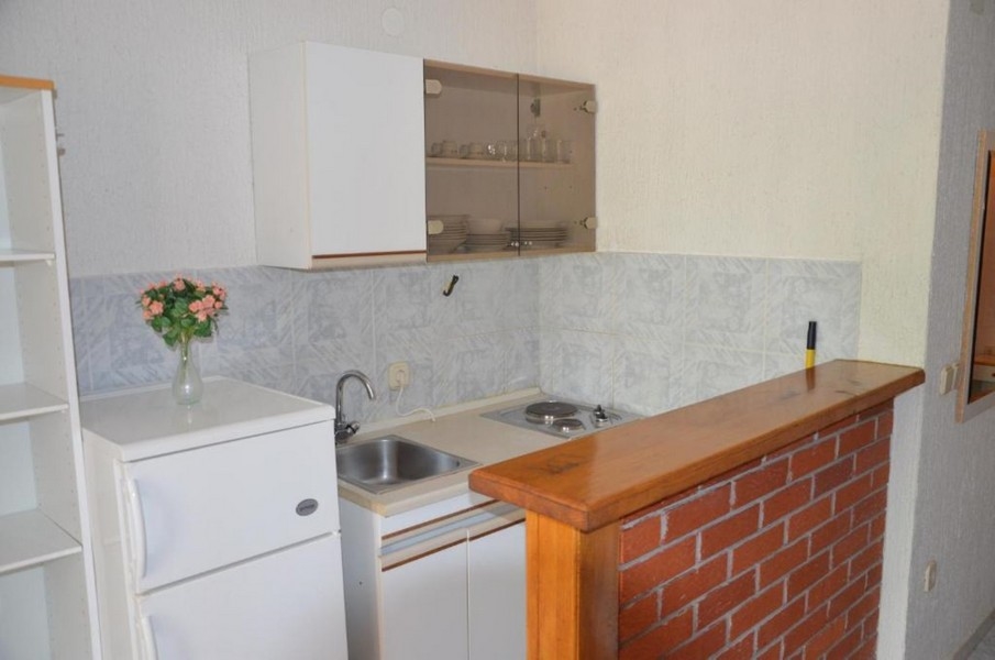 Petite cuisine linéaire avec comptoir en bois et surfaces claires