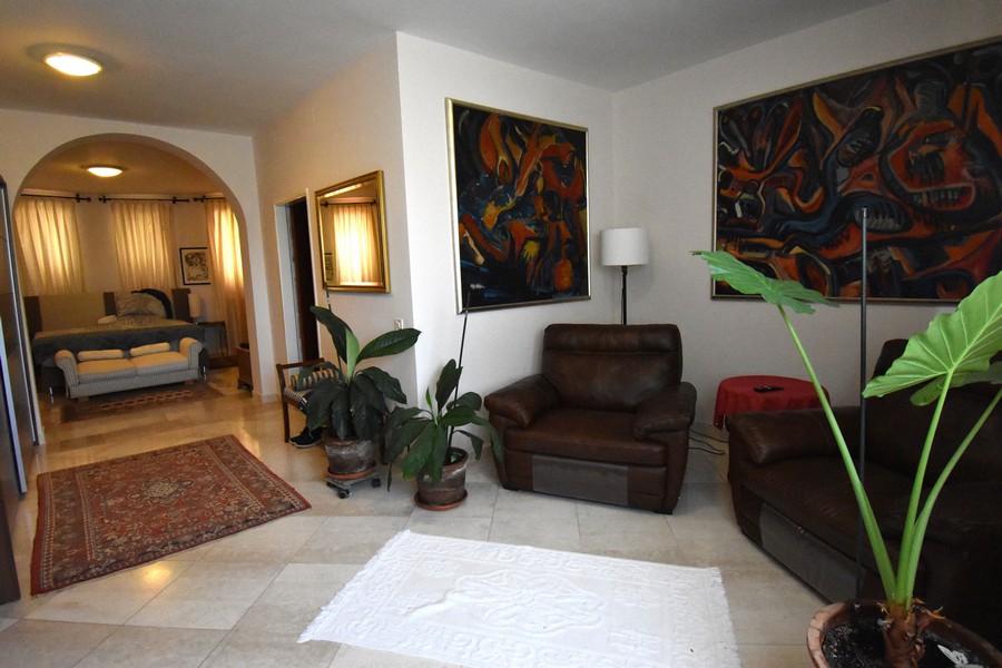 Séjour avec fauteuils en cuir et grands tableaux au mur