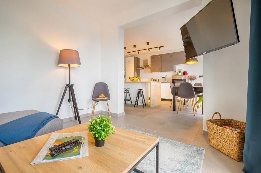 Séjour avec lampadaire et cuisine ouverte