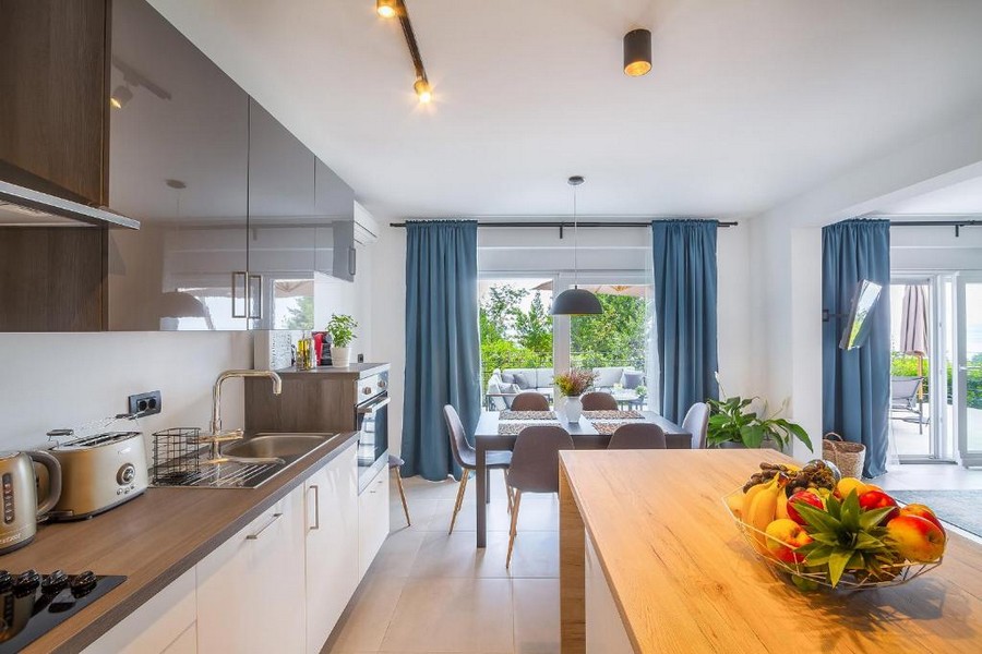 Cuisine ouverte avec table et porte de terrasse