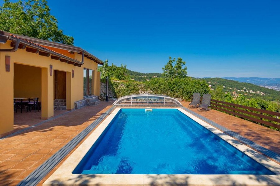 Piscine et terrasse couverte avec vue mer