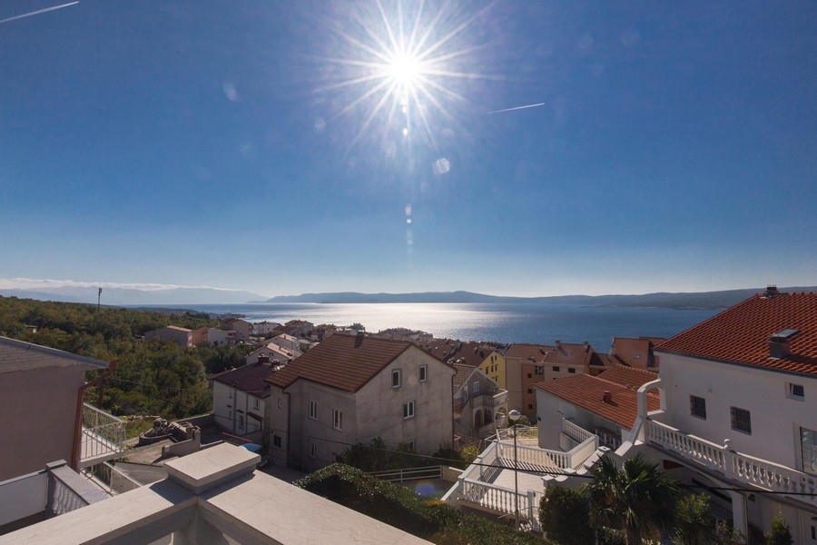 Soleil au-dessus de la baie avec toits en tuiles au premier plan