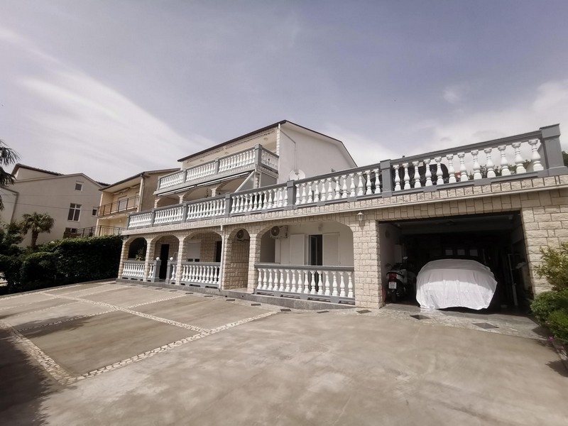 Cour d'entrée avec places de stationnement et garage sous les balcons