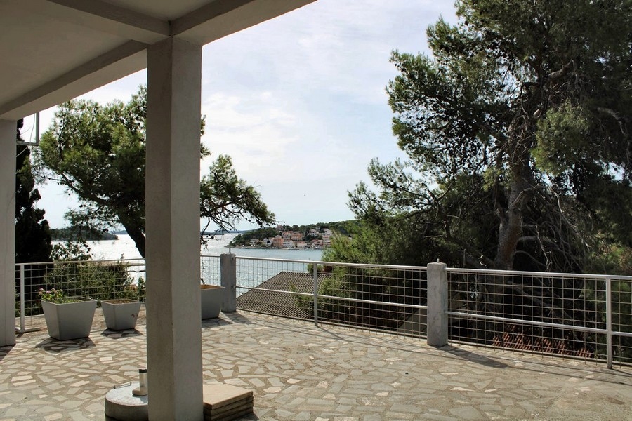 Terrasse couverte avec colonnes et vue sur le village