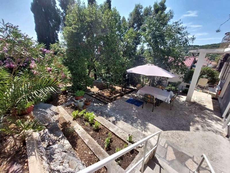 Terrasse de jardin avec parasol et marches en pierre