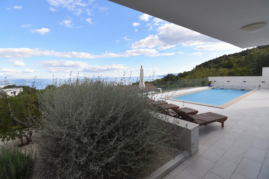 Piscine avec bains de soleil et vue mer