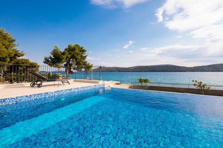Piscine à débordement avec carrelage en mosaïque directement au-dessus de l'eau