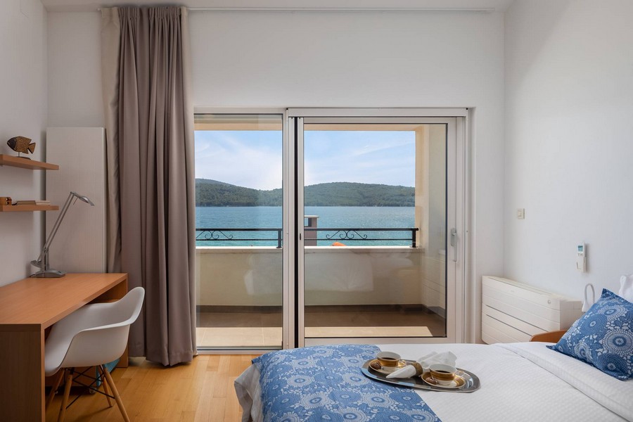 Chambre avec bureau et porte de balcon donnant sur la baie