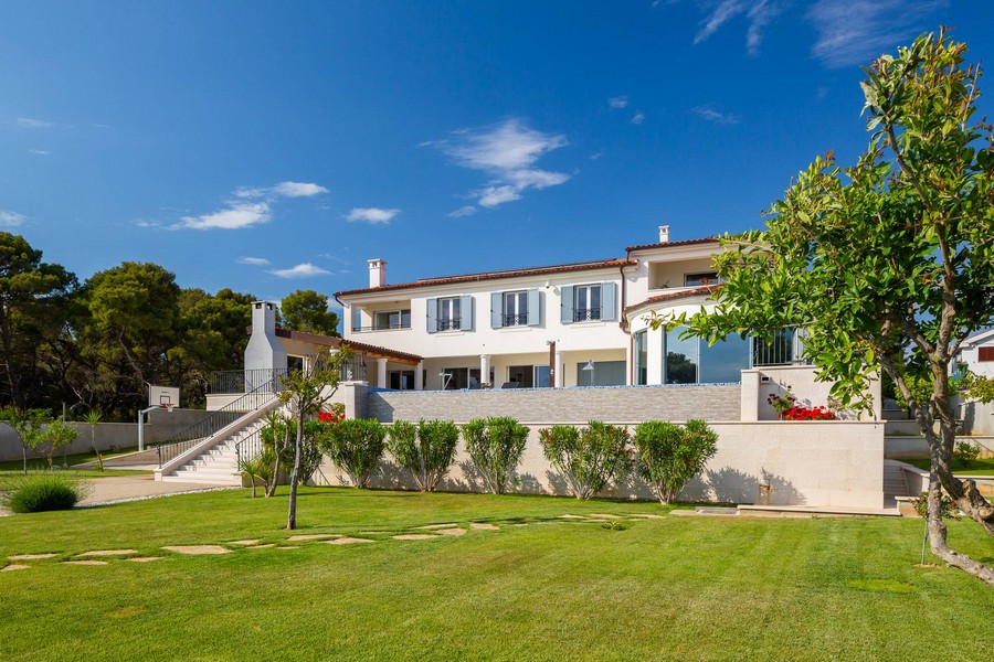 Villa avec pelouse et escalier extérieur menant à l'entrée