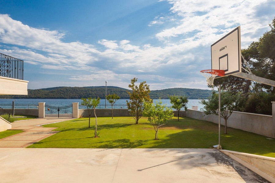 Pelouse avec panier de basket et vue sur la baie
