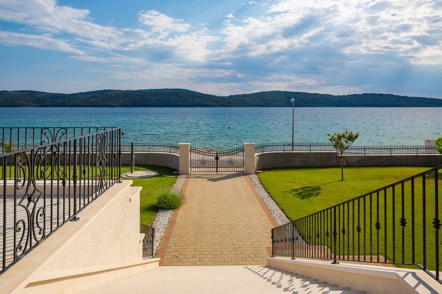 Chemin pavé à travers le portail jusqu'au rivage privé