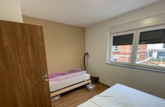 Chambre d'enfant avec lit parapluie et fenêtre donnant sur le voisinage
