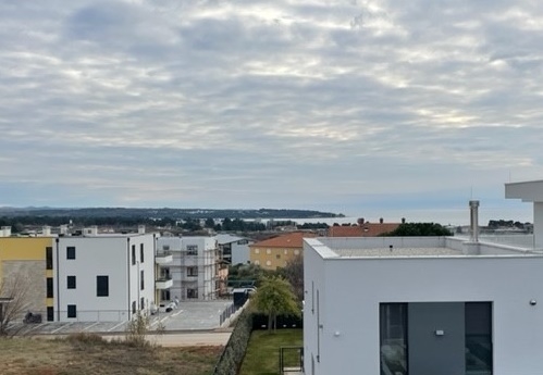 Vue au-dessus des maisons jusqu'à la mer par ciel nuageux