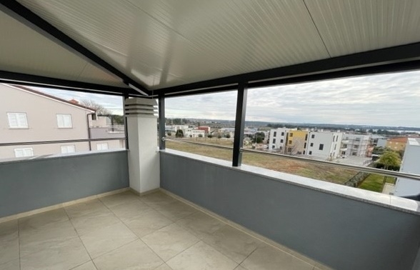 Terrasse d'angle sous le toit avec vue sur les environs